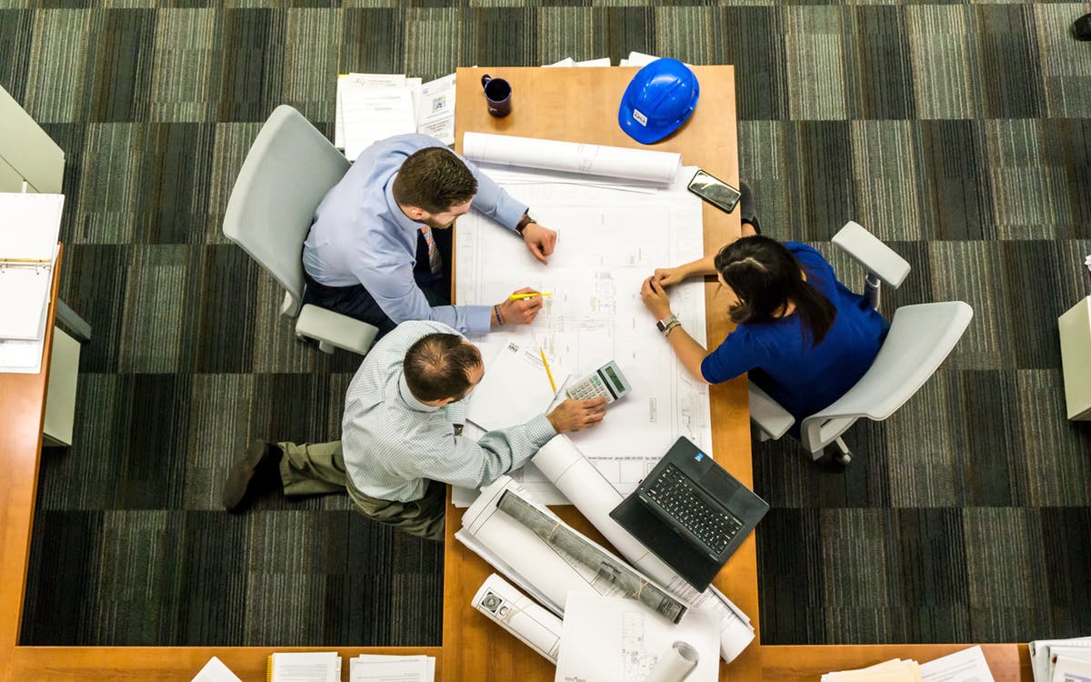 Three people seated at a desk