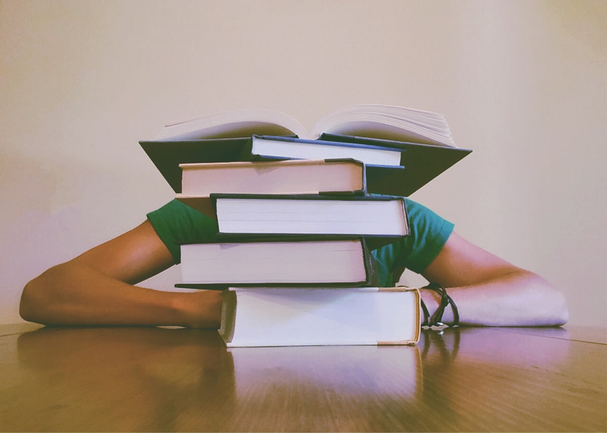 High school student behind books