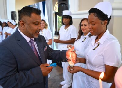 A nursing graduate has her lamp lit.