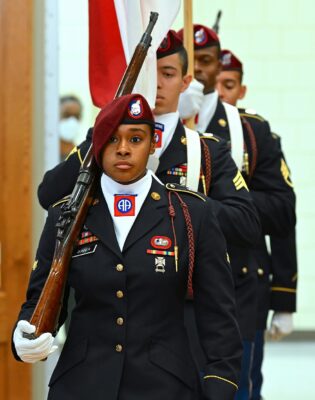 Members of the 82nd Airborne Color Guard carry the flags.