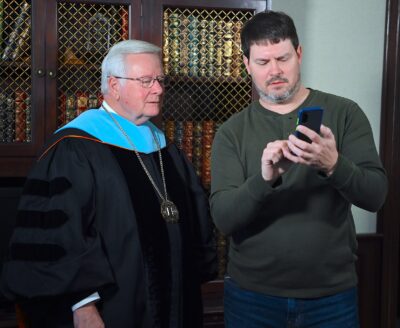 Dr Larry Keen and artist Todd Carignan look at a photo on Carignan's phone