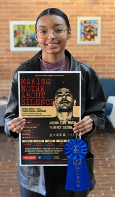 Terra Smith holds her poster with a blue first place ribbon.