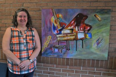 Yvette Andrews stands next to her artwork, "Jazz Expression."