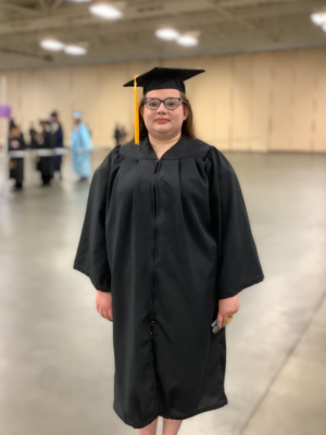 Tabitha McLamb, dressed in cap and gown, stands in the staging area.