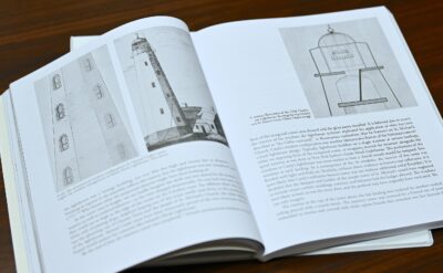 An open book with illustrations on both pages of lighthouses.