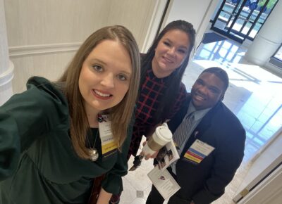 Three people take a selfie.