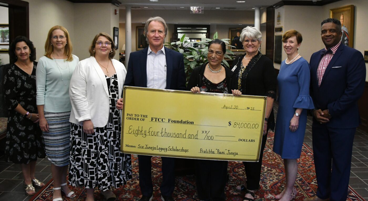 A group of people stand behind a presentation check.