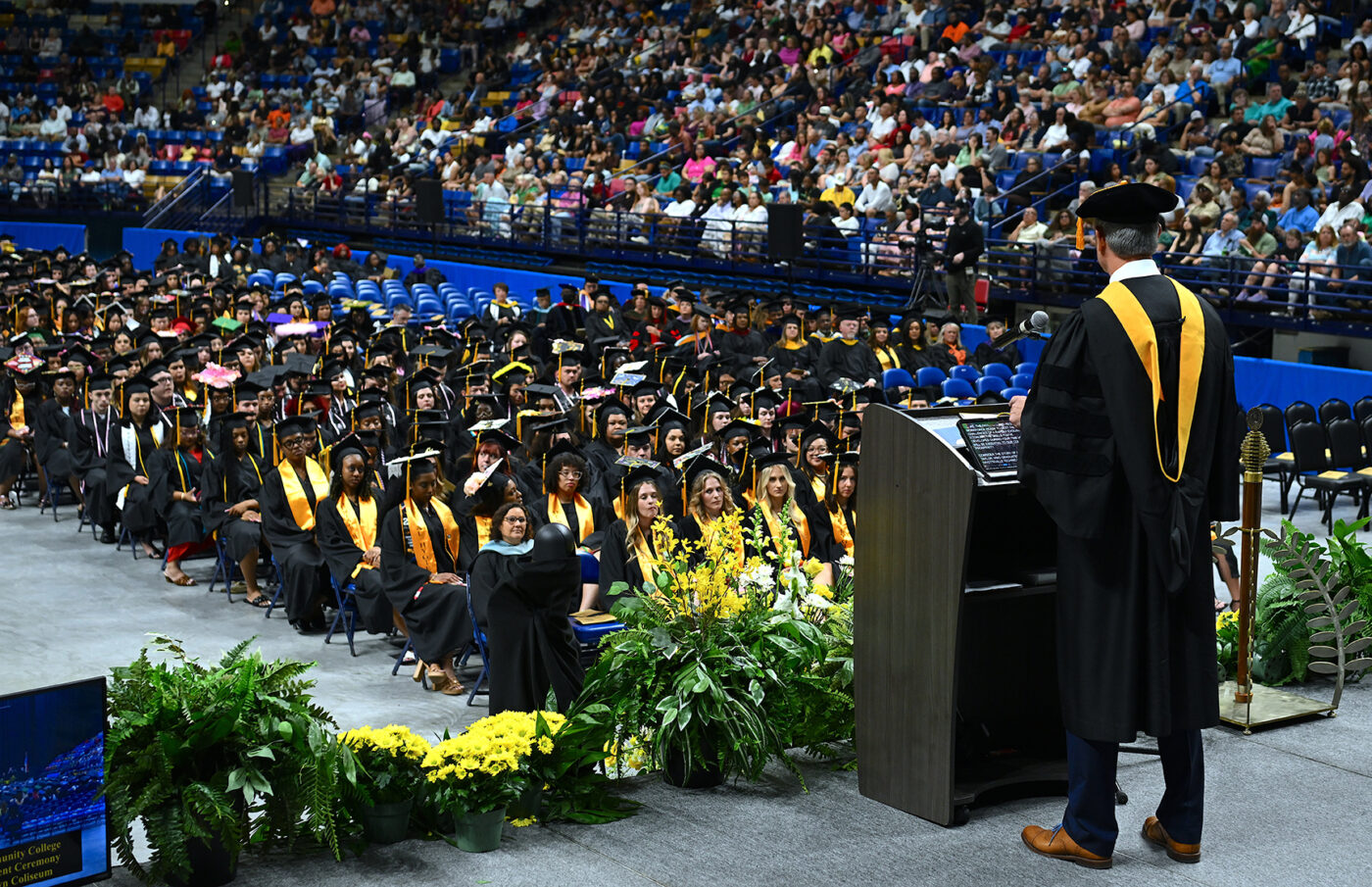 A man speaks on stage at graduation.
