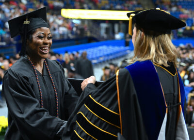 A graduate shakes hands with FTCC Senior Vice President Dr. Murtis Worth.