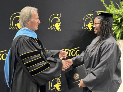 Dr Mark Sorrells shakes hands with a graduate