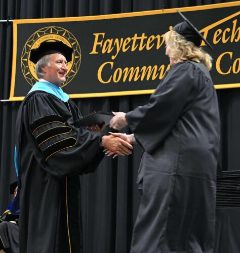 Dr.-Sorrells-shakes-the-hand-of-a-graduate-as-he-hands-her-her-diploma