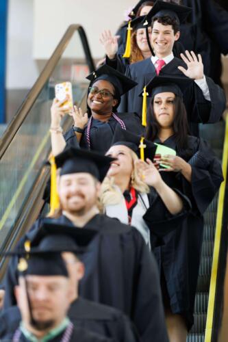 Graduates-smile-and-wave-as-they-ride-down-the-escalator-on-the-way-to-the-Crown