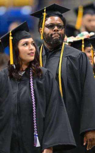 Two-graduates-gaze-pensively-off-camera-as-they-wait-to-go-onto-the-stage