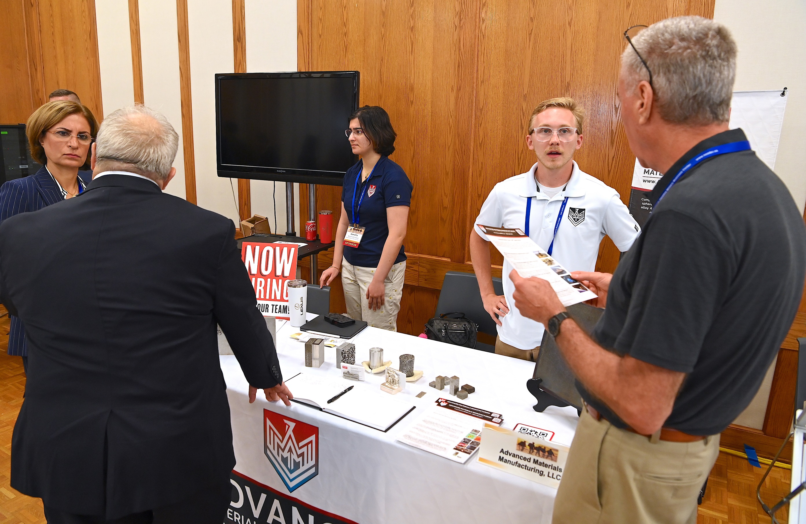 Vendors speak at a table at the Defense Technology Symposium.