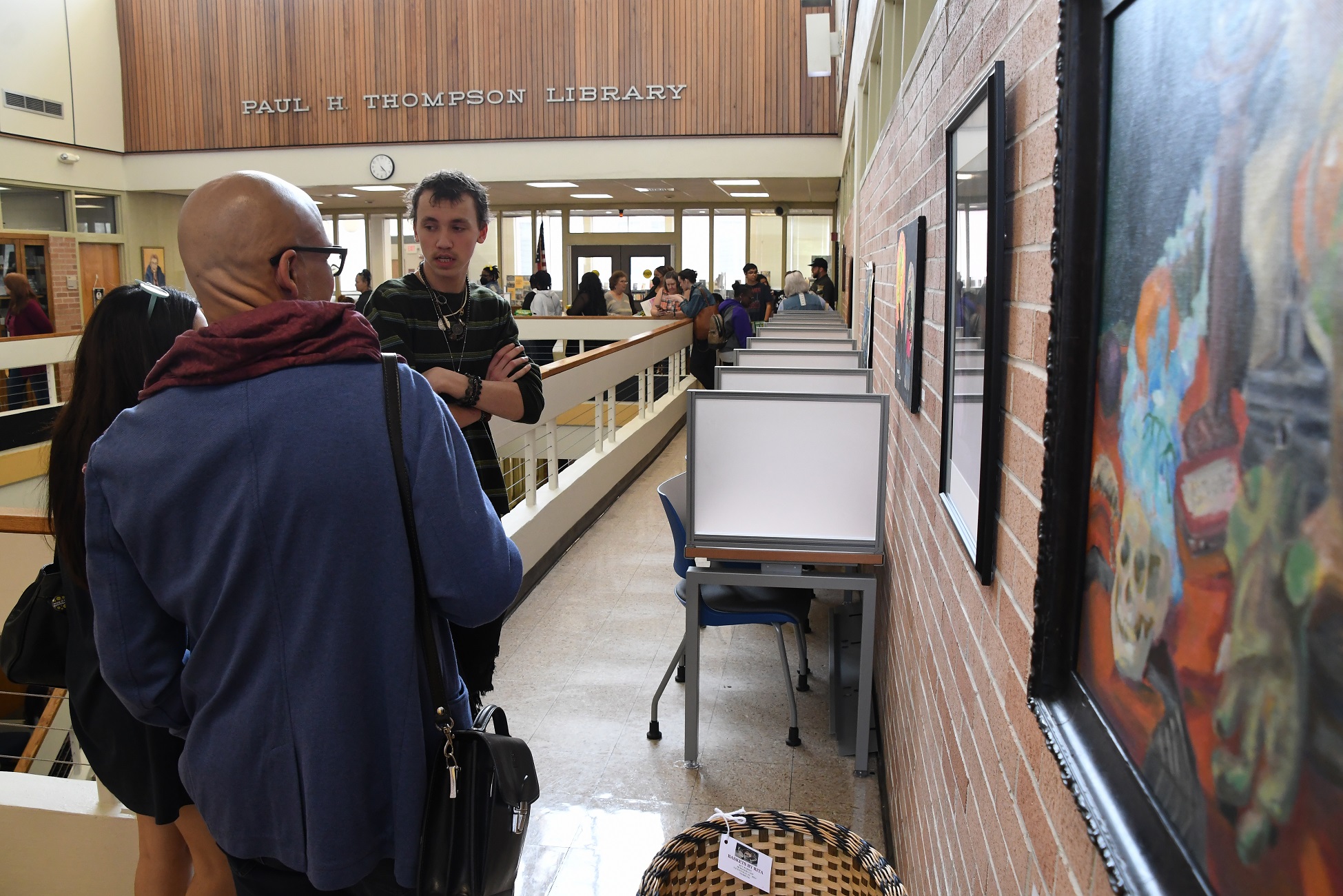 Visitors enjoy the artwork on the second floor of the the Paul H. Thompson Library.