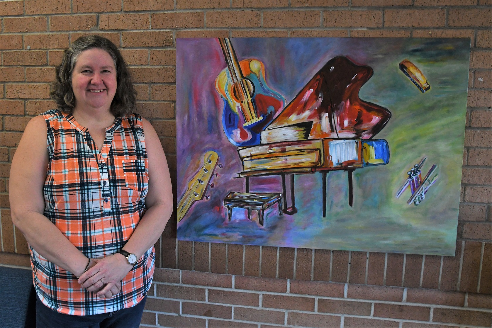 Yvette Andrews stands beside her painting, "Jazz Expression," for which she was awarded second place.