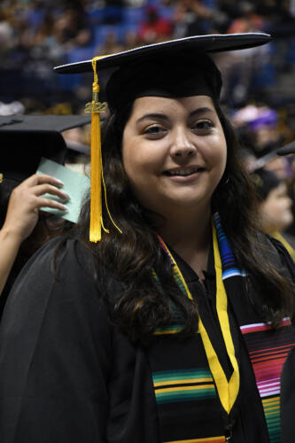 A close-up photo of a graduate smiling at the camera.