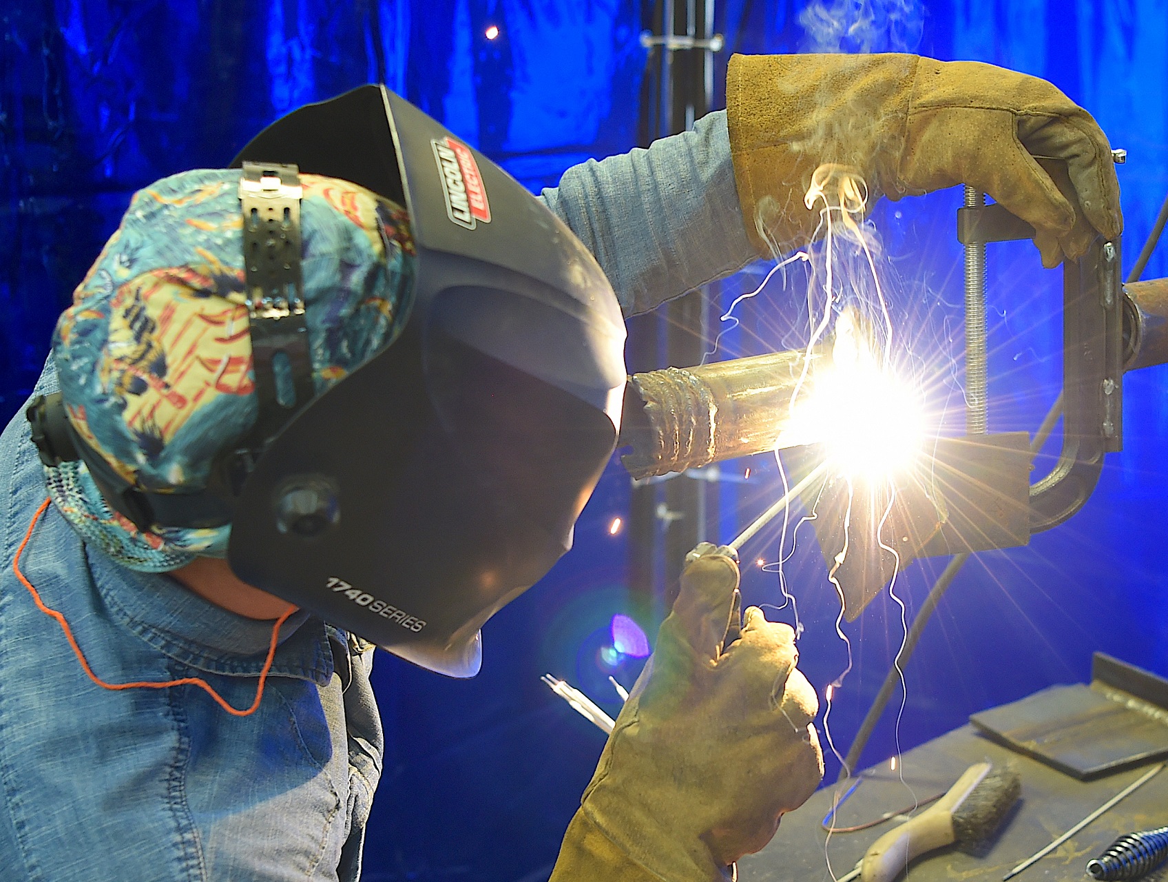 A student welds a piece of metal.