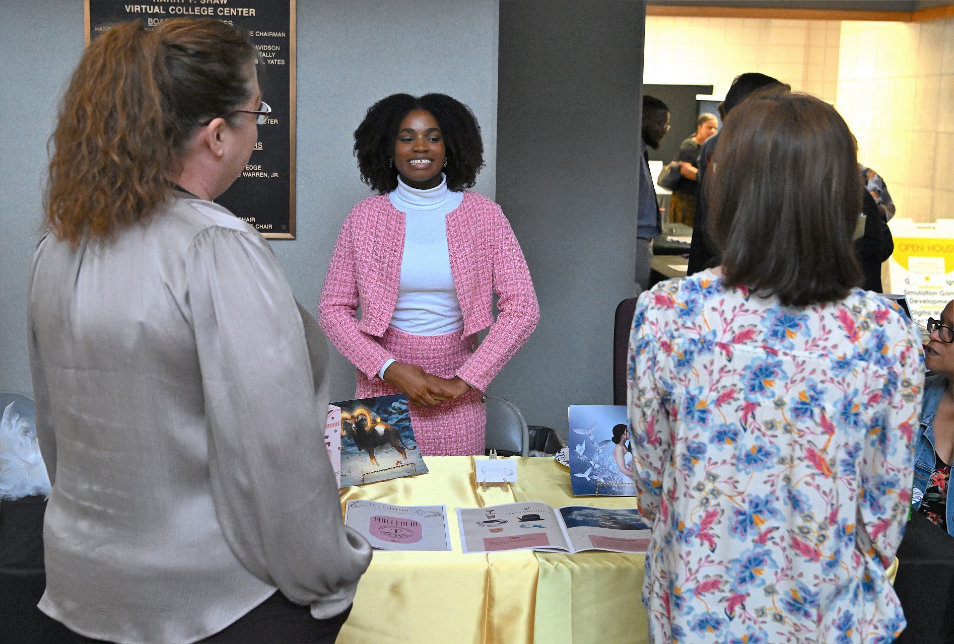 A graduate talks with two women at her table.