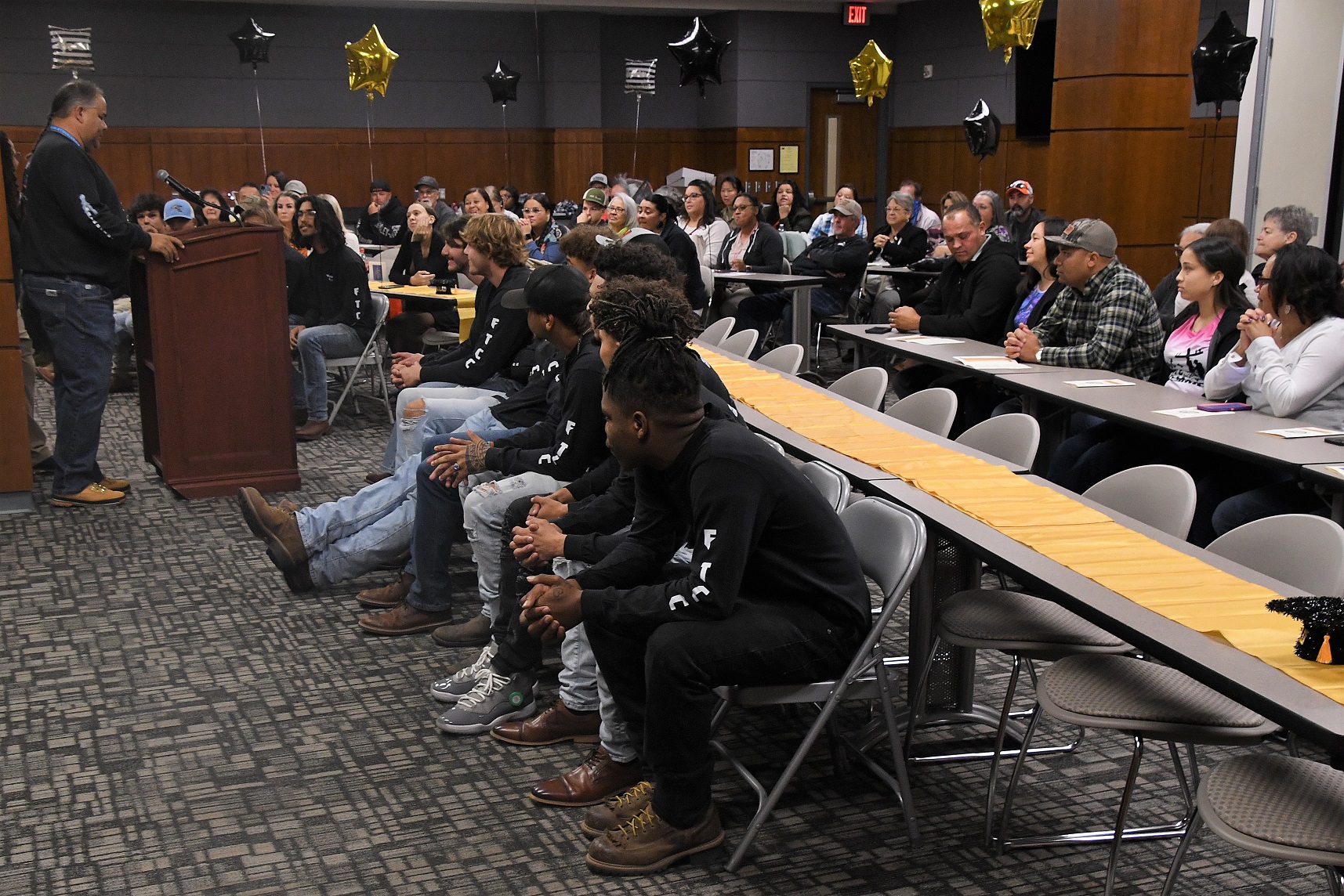 A wide photo of the graduates and audience members seated during the ceremony.