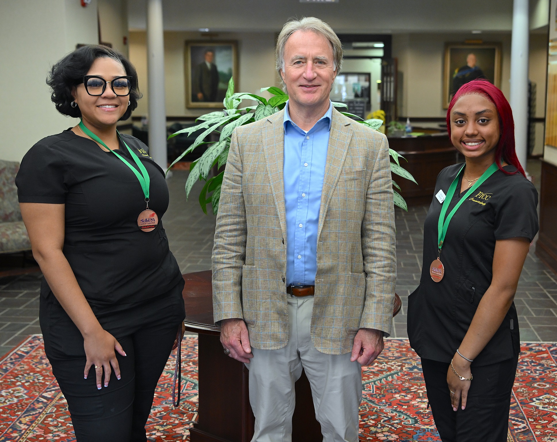 Ashlyn Stanislas and Syriah Lewis (5th place, Skilled Showcase- Cosmetology Team) stands with FTCC President Dr. Mark Sorrells.