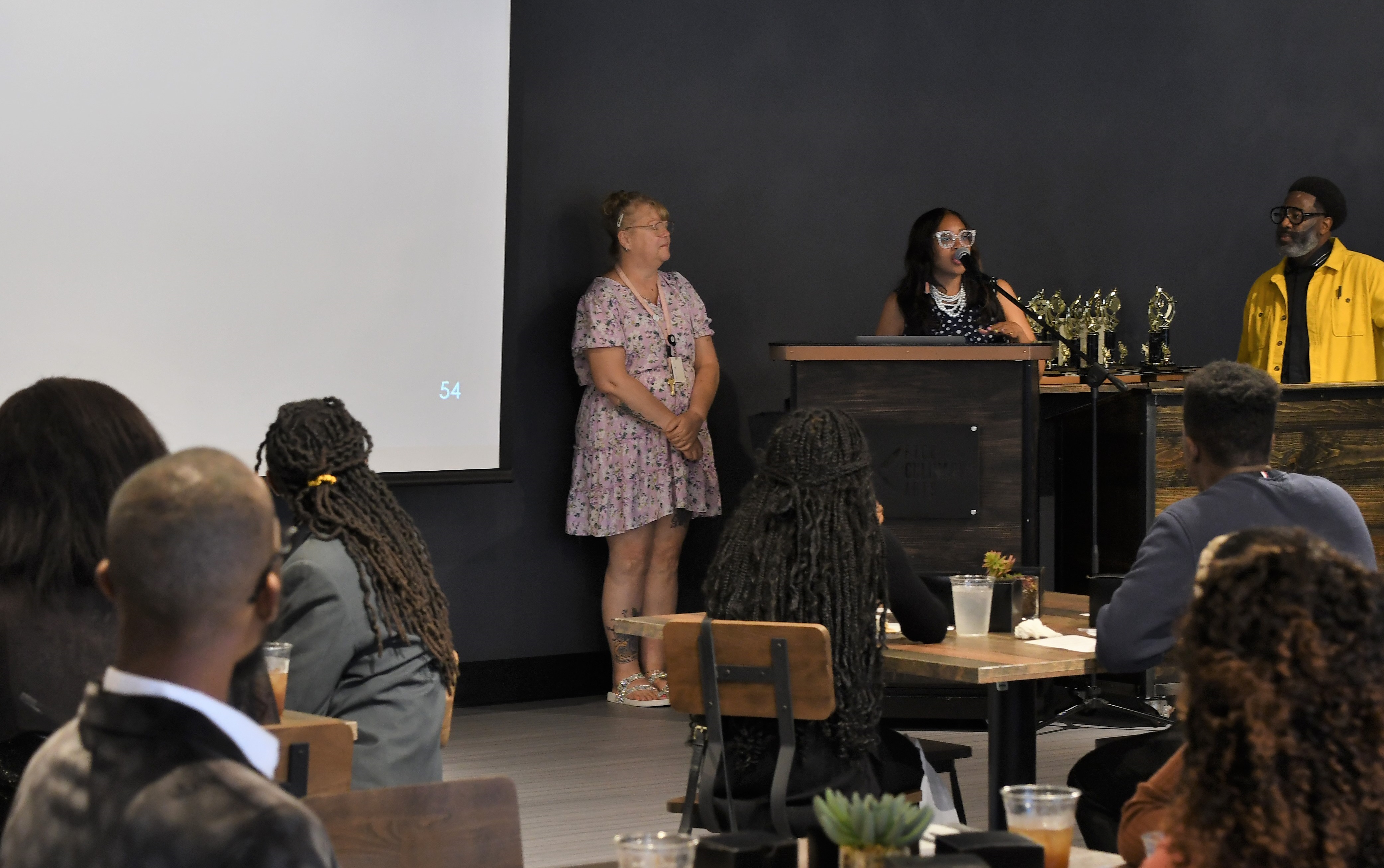 Dr. Kenjuana McCray speaks at the podium at the front of the dining hall.