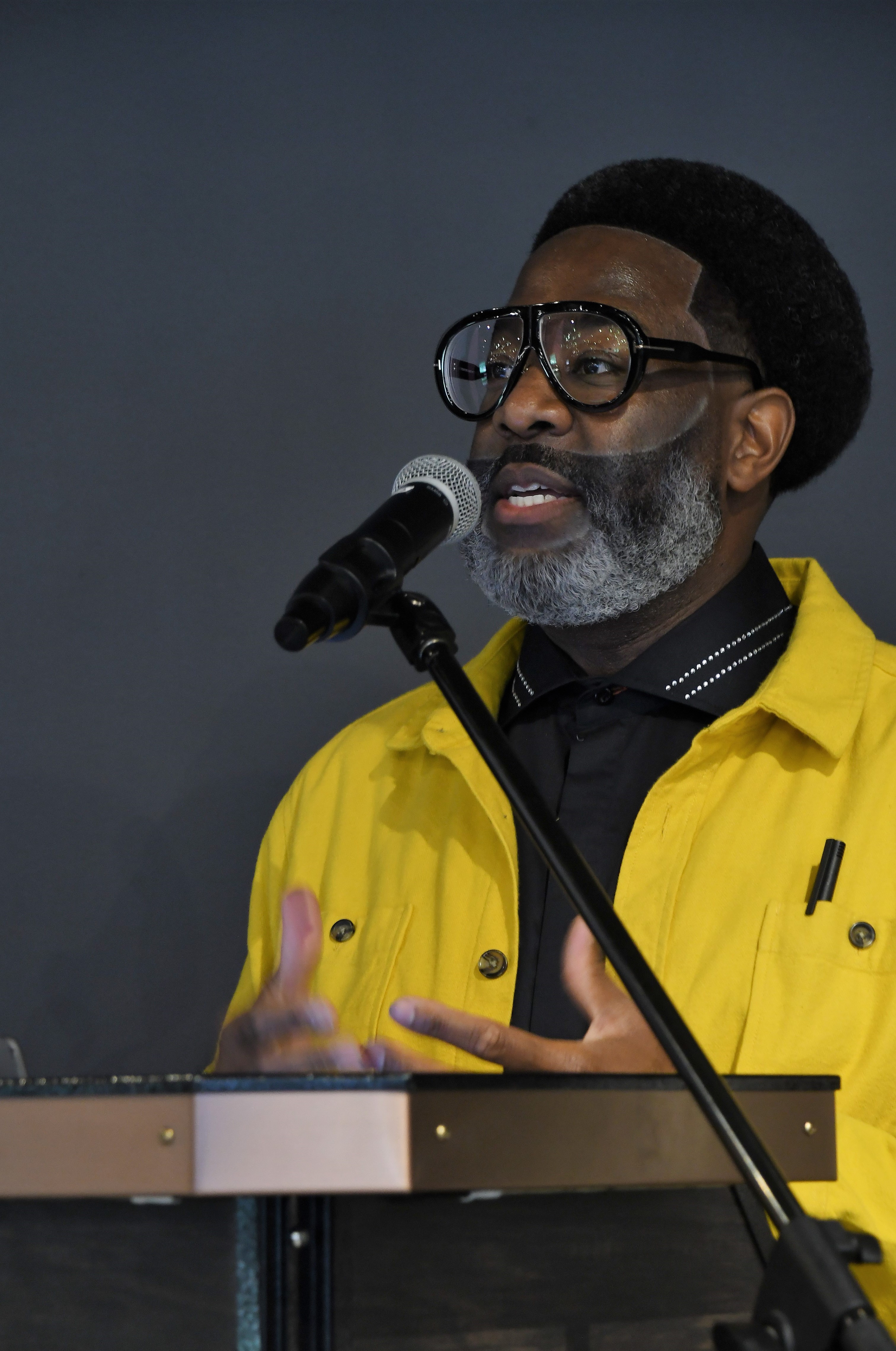 A close-up photo of Richard McDonald speaking at the podium.