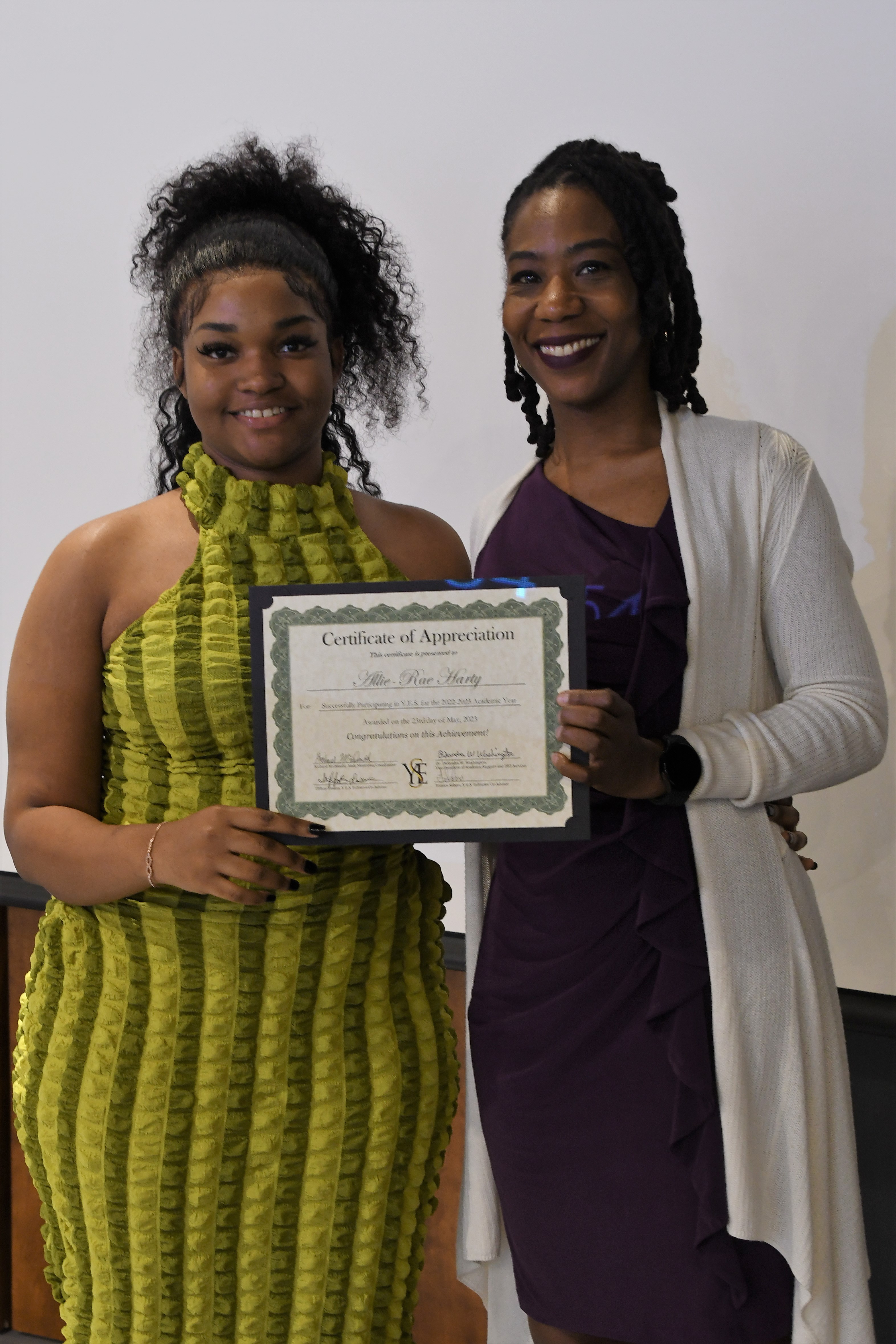 A student receives her Certificate of Appreciate for participating in the YES Initiative.