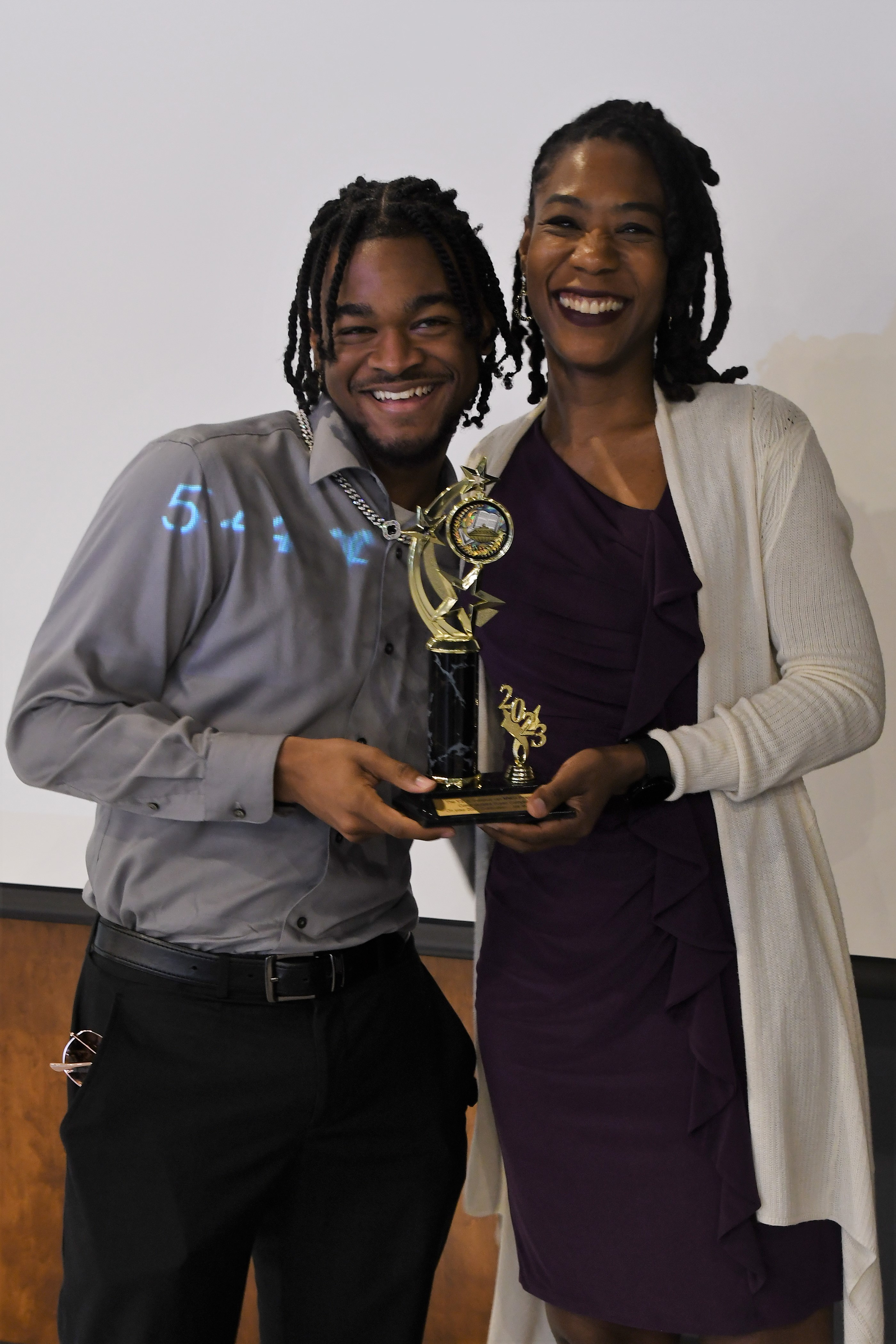 A student receives a trophy of special recognition.